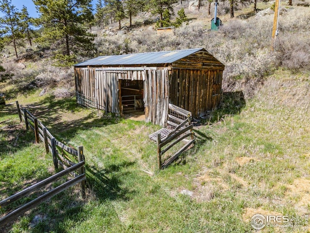 view of yard featuring fence, an outdoor structure, and an outbuilding