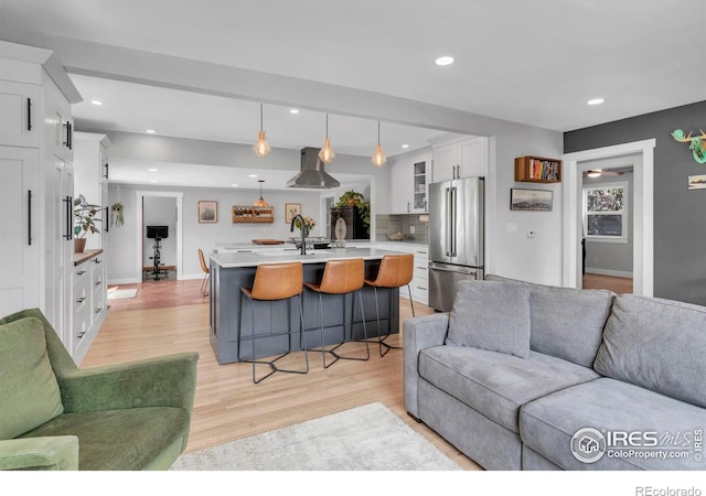living room with light wood-style flooring, recessed lighting, and baseboards