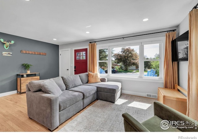 living room featuring plenty of natural light, light wood finished floors, recessed lighting, and baseboards