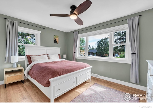 bedroom with baseboards, light wood-style flooring, and a ceiling fan