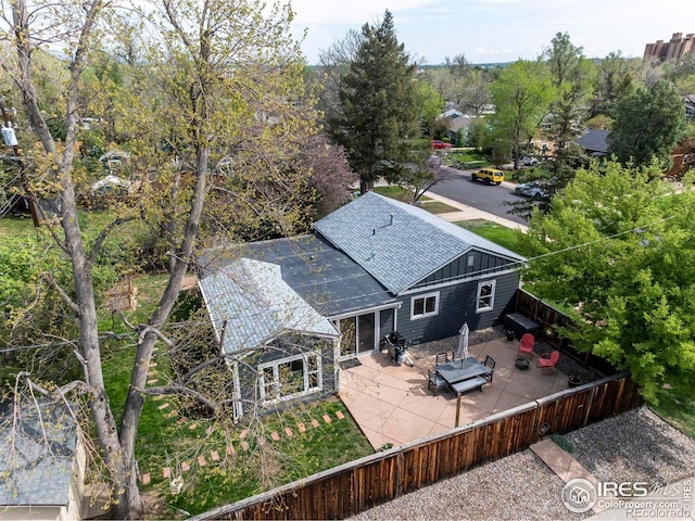 back of property featuring a patio area, a shingled roof, a fenced backyard, and board and batten siding