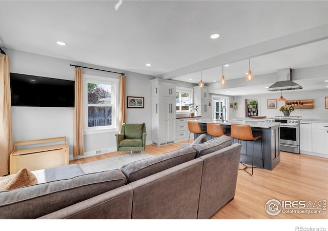 living area with light wood finished floors, recessed lighting, and baseboards
