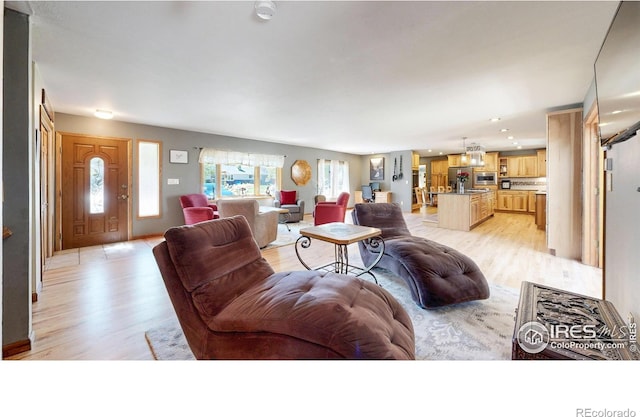 living area with light wood finished floors and recessed lighting