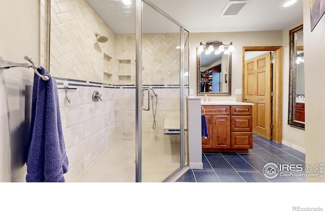 bathroom featuring tile patterned floors, a stall shower, and vanity