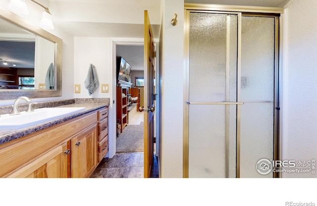 full bath featuring a stall shower and vanity