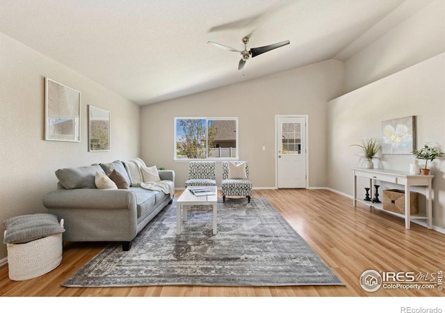living room with wood finished floors, ceiling fan, lofted ceiling, and baseboards