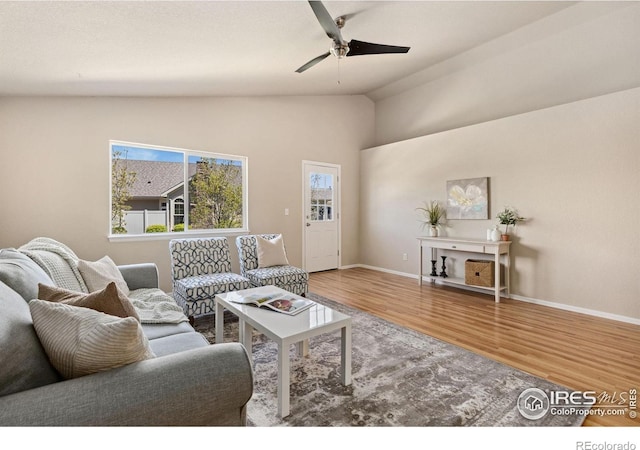 living room featuring wood finished floors, ceiling fan, baseboards, and high vaulted ceiling