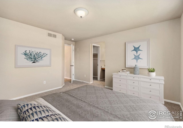 bedroom with carpet floors, baseboards, and a walk in closet