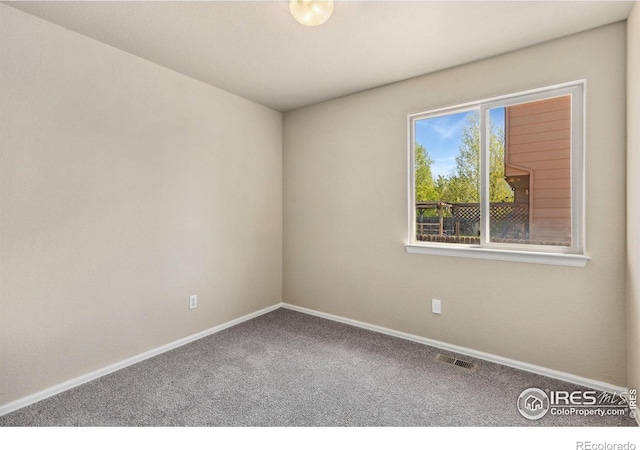 unfurnished room featuring carpet floors and baseboards