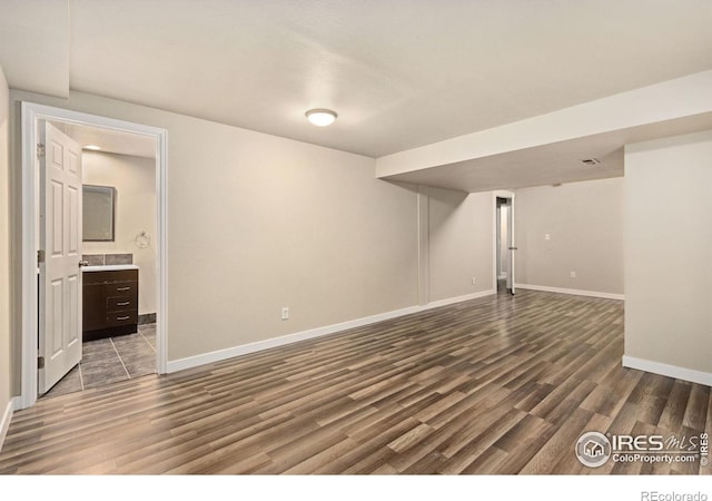 finished below grade area featuring wood finished floors and baseboards