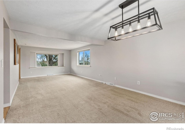 unfurnished room featuring carpet, baseboards, and a textured ceiling