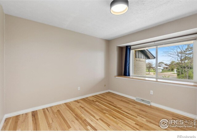 unfurnished room featuring light wood-style floors and baseboards