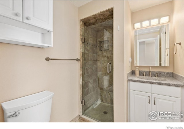 bathroom with a stall shower, toilet, and vanity