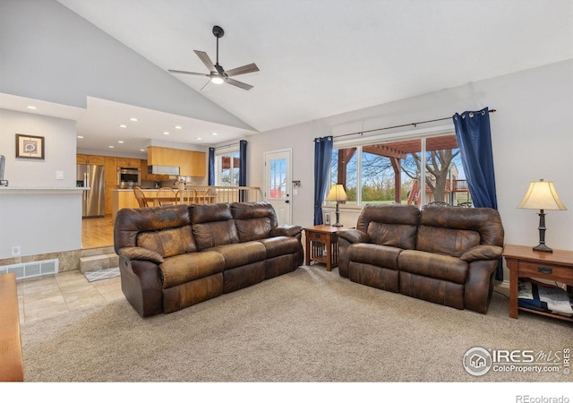 living area with a ceiling fan, recessed lighting, high vaulted ceiling, light carpet, and light tile patterned floors