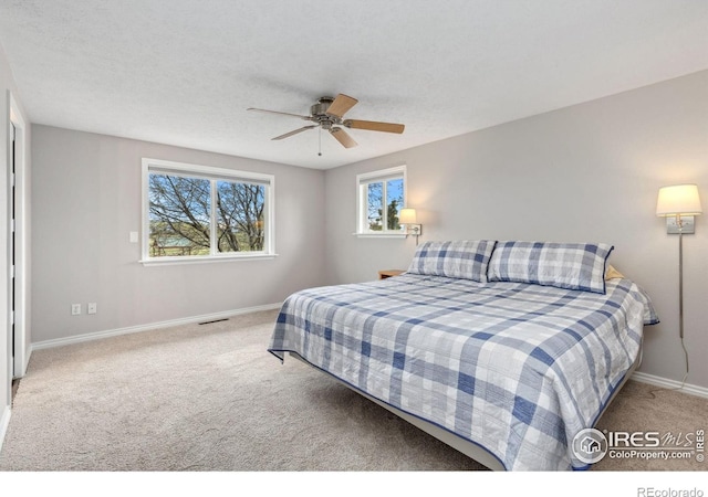 carpeted bedroom featuring baseboards and a ceiling fan