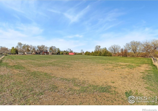 view of green lawn featuring a view of rural / pastoral area