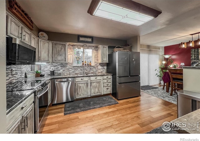 1561 Belmont Dr, Longmont, CO 80503 - kitchen featuring appliances with stainless steel finishes, a sink, tasteful backsplash, and light wood finished floors