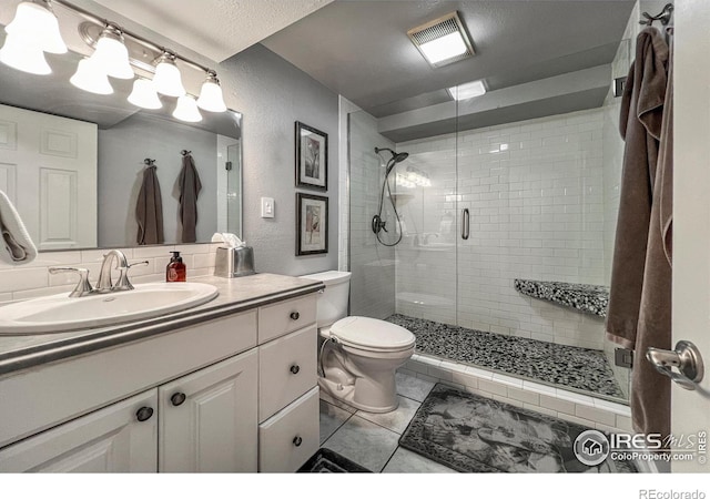 1561 Belmont Dr, Longmont, CO 80503 - full bath featuring toilet, a shower stall, vanity, tile patterned flooring, and a textured wall