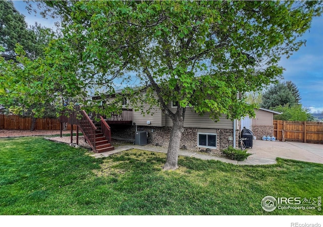 1561 Belmont Dr, Longmont, CO 80503 - back of property with stairs, a patio area, a wooden deck, central air condition unit, and brick siding