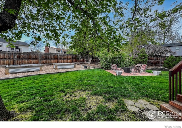 1561 Belmont Dr, Longmont, CO 80503 - view of yard featuring a patio area, a vegetable garden, and a fire pit