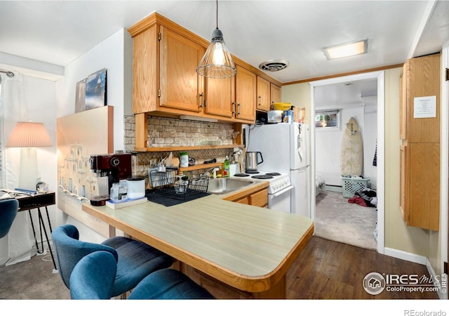 kitchen with a peninsula, light countertops, tasteful backsplash, white electric stove, and pendant lighting