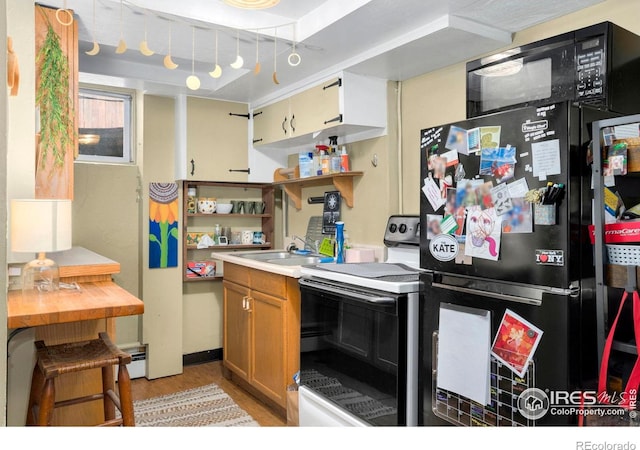 kitchen with electric range, freestanding refrigerator, a sink, open shelves, and light wood-style flooring