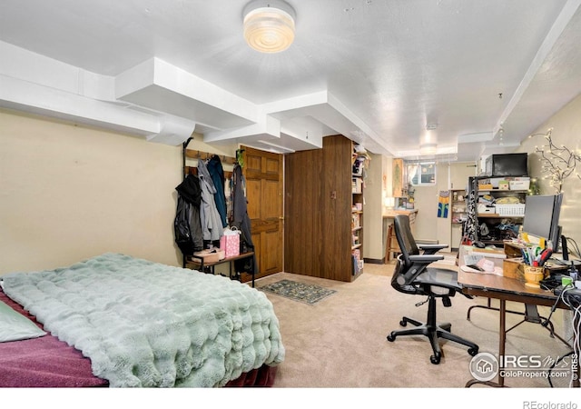 carpeted bedroom with an office area