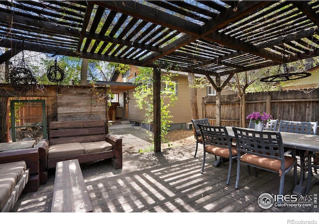 view of patio featuring fence, outdoor dining space, a pergola, and a deck