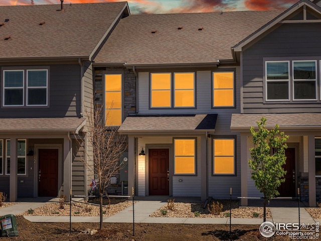 townhome / multi-family property with a shingled roof