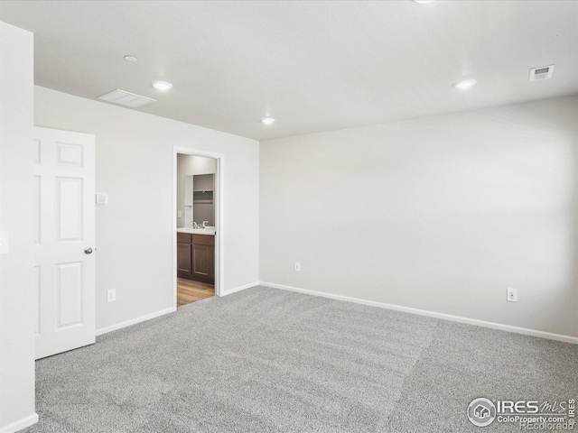 carpeted spare room featuring baseboards and recessed lighting