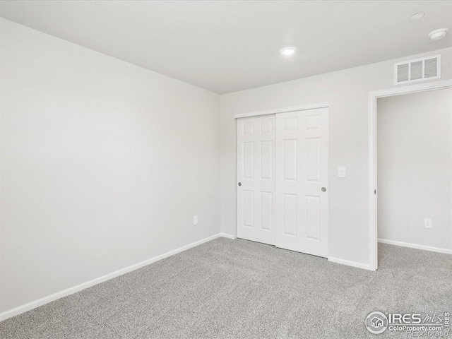 unfurnished bedroom featuring carpet floors, baseboards, a closet, and recessed lighting