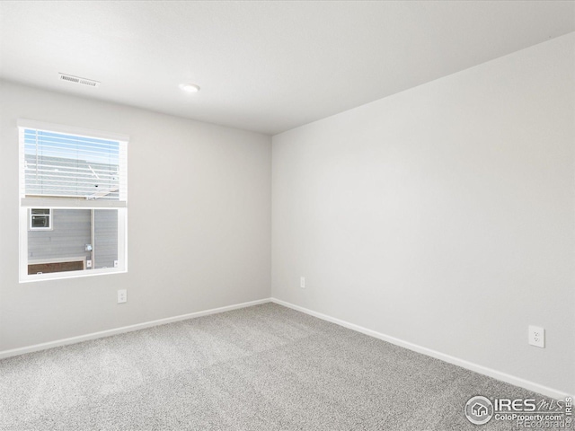 carpeted empty room with baseboards