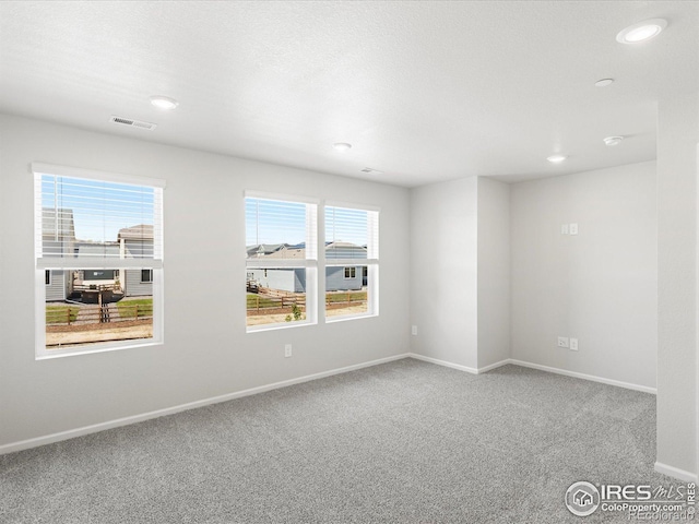 carpeted empty room featuring baseboards and recessed lighting
