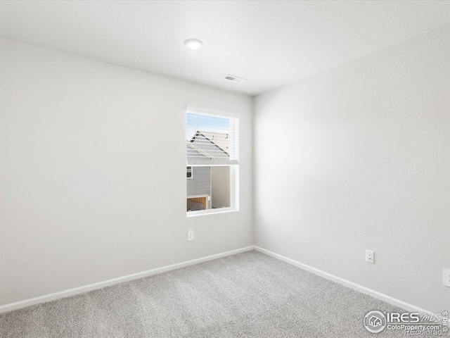carpeted spare room featuring baseboards