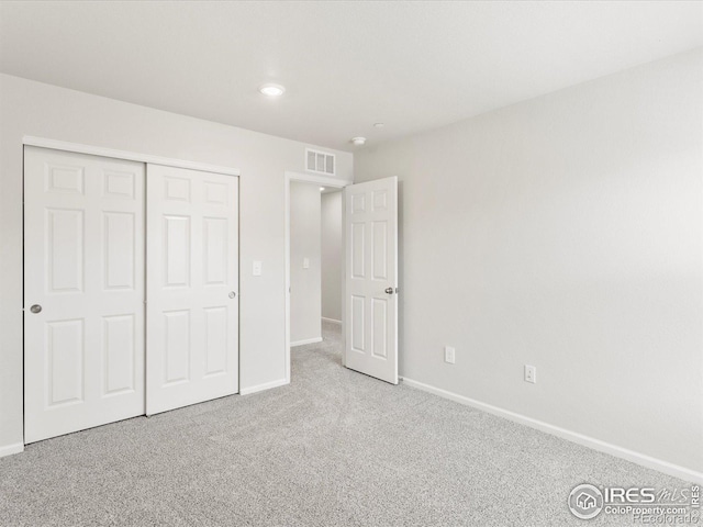 unfurnished bedroom featuring baseboards, carpet floors, a closet, and recessed lighting