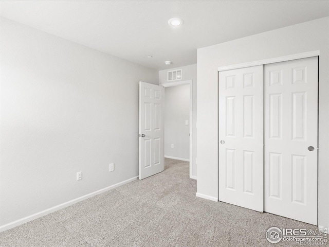 unfurnished bedroom with carpet, baseboards, and a closet
