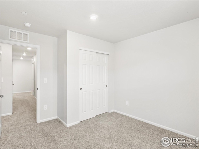 unfurnished bedroom featuring carpet floors, baseboards, a closet, and recessed lighting
