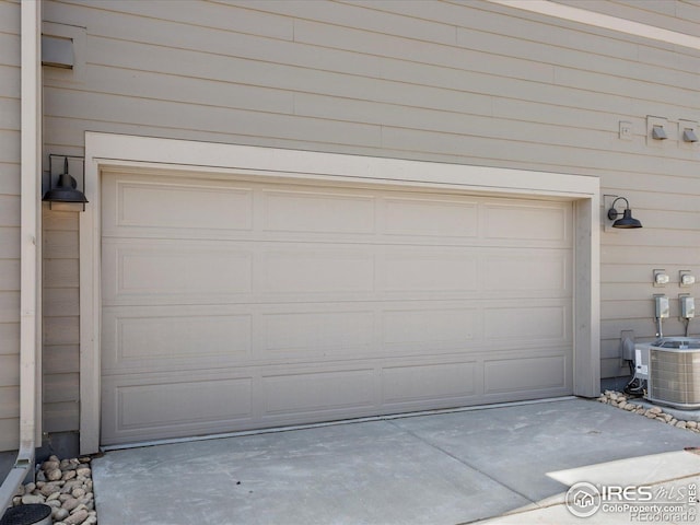 garage with central AC unit and driveway