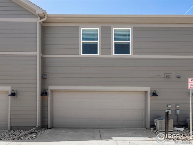 garage with central air condition unit and driveway