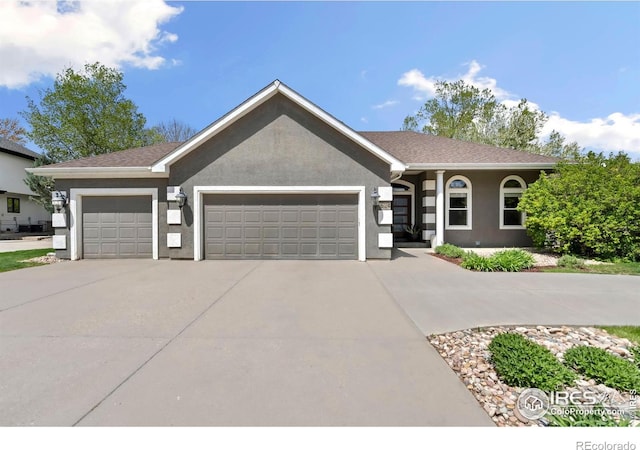 single story home featuring a garage, concrete driveway, and stucco siding