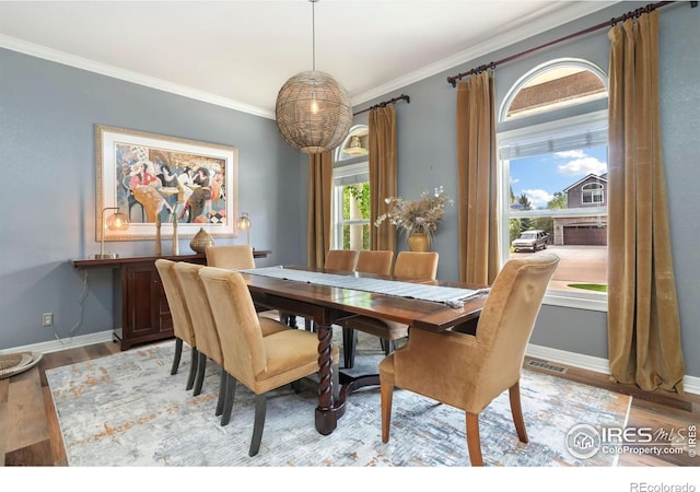 dining space featuring ornamental molding, light wood-type flooring, and baseboards