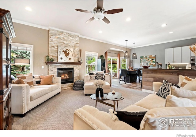 living room featuring arched walkways, healthy amount of natural light, ceiling fan, a fireplace, and recessed lighting