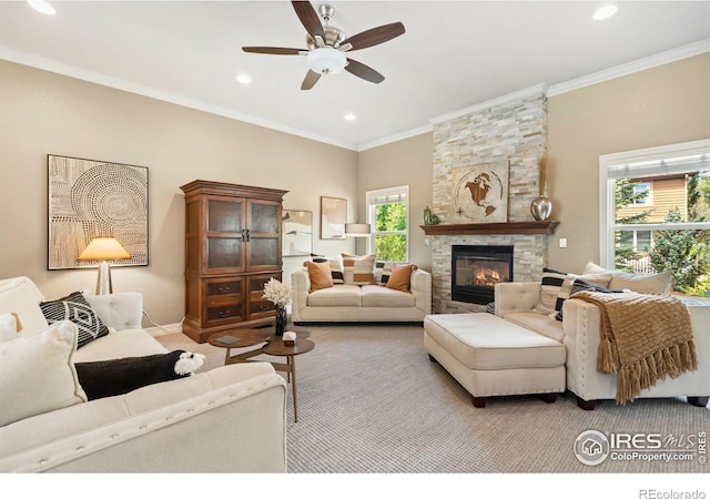 living room with healthy amount of natural light, ceiling fan, recessed lighting, a stone fireplace, and ornamental molding