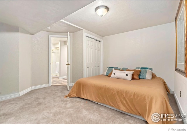 bedroom with baseboards, carpet floors, and a closet