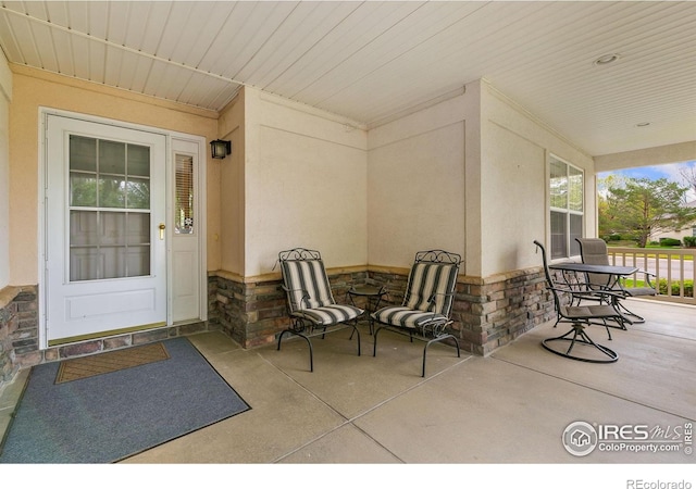 1380 Swainson Rd, Eaton, CO 80615 - view of exterior entry with stone siding, covered porch, and stucco siding