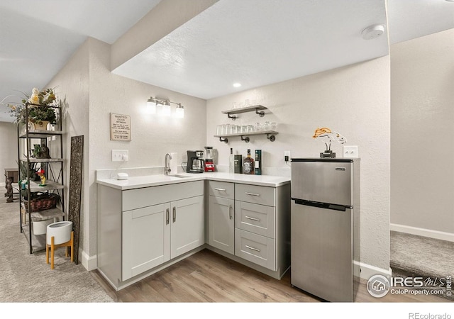 1380 Swainson Rd, Eaton, CO 80615 - bar area with freestanding refrigerator, a sink, baseboards, light wood-style floors, and light carpet