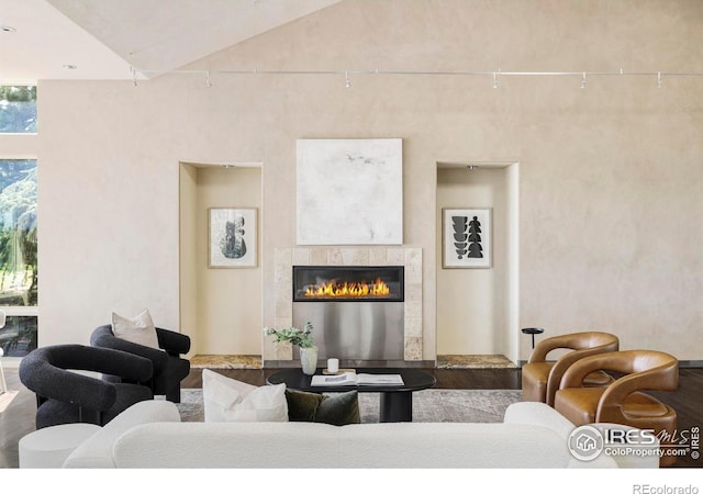 living area featuring lofted ceiling and a tiled fireplace