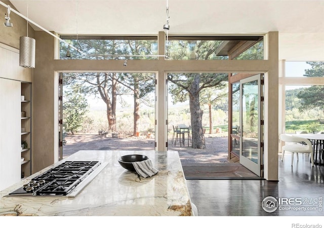 doorway to outside with a towering ceiling, wood finished floors, and built in features