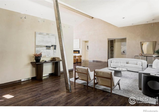 living room with wood finished floors, a warm lit fireplace, and baseboards