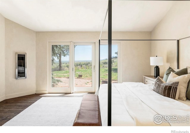 bedroom with access to outside, wood finished floors, and baseboards